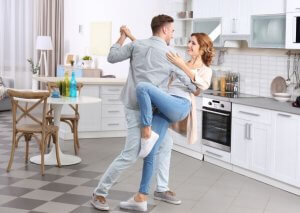 Couple stopping depression by dancing in the kitchen.