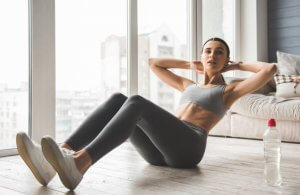 Exercises: woman doing abs at home.