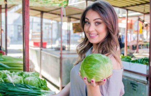 kvinde der køber grøntsager på grøntmarked