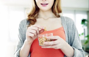 Woman eating healthy foods such as nuts.