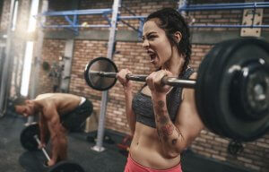 Woman training with barbell to build muscles.
