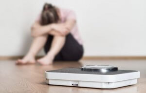 Unhappy woman and scale