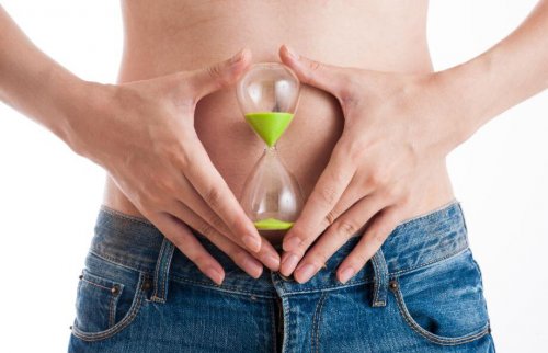 Woman holding hourglass in front of belly