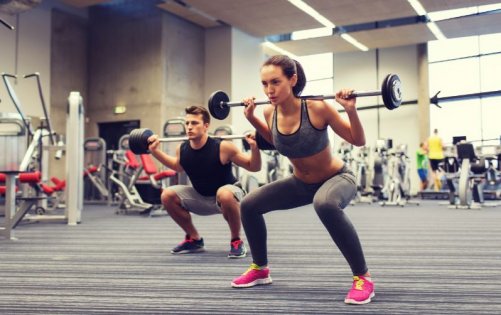 Woman and man strength training with squats.