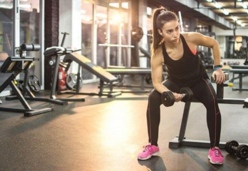 Sports motivation woman on bench with dumbbell