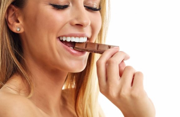 kvinde der spiser et stykke af en plade chokolade
