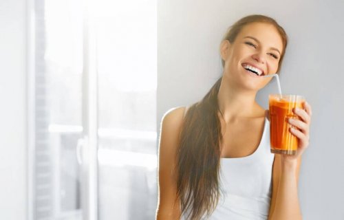 Woman laughing while drinking smoothie