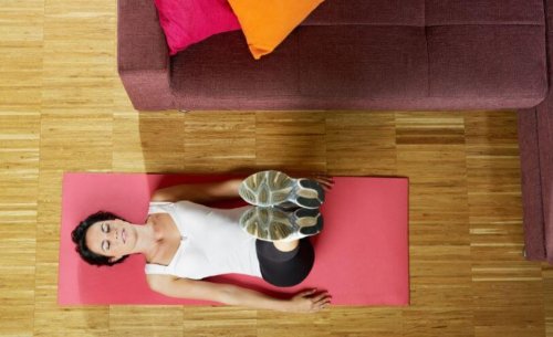 Work out at home woman doing yoga on floor with legs extended