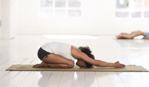 Woman doing child pose one of the best stretches for back pain.