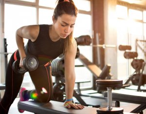 Woman doing many exercises with dumbbells.