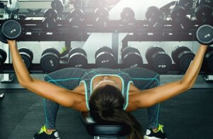 Woman using free weights for her chest.