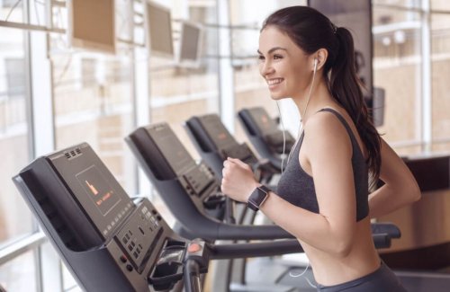 Woman smiling while listening to music and running on treadmill best treadmills