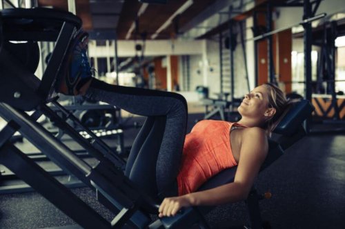 A woman performing a leg press in the gym.