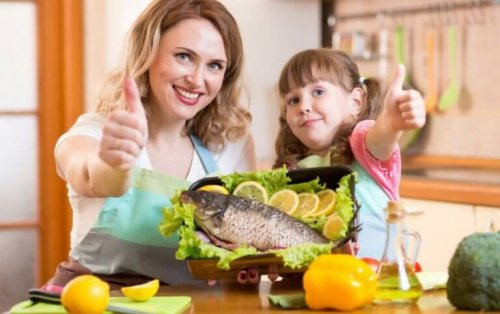 Woman and daughter posing with thumbs up in front of dead fish