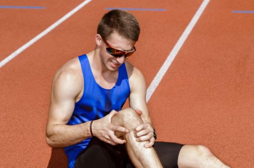 A man whose knee is injured from a track and field sport.