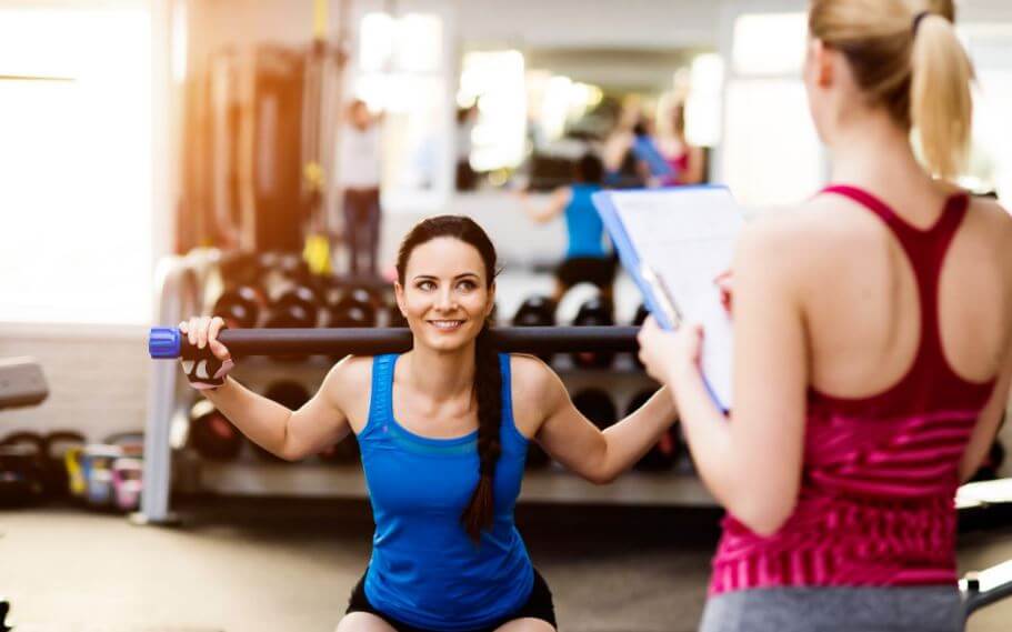 woman in gym with trainer