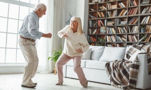 Elderly couple dancing together at home using app bailonga