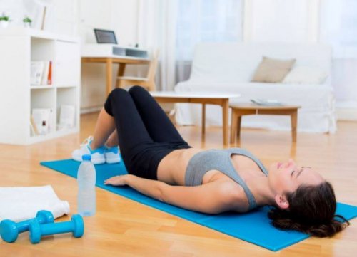 Woman doing yoga back on floor knees bent postpartum exercises