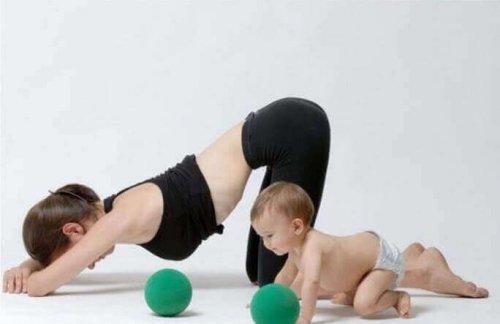 Woman doing yoga next to her infant son postpartum exercises