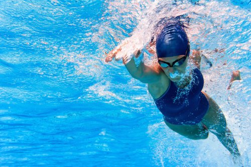 Woman swimming front crawl in pool