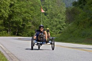 Man riding a recumbent bike on a road