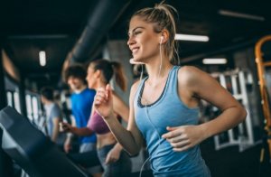 Woman using a heart rate monitor as she runs on the treadmill