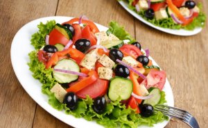 A greek salad with a lot of olives