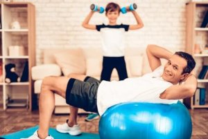 Father and son doing exercise in the living room dumbbells exercise with your family