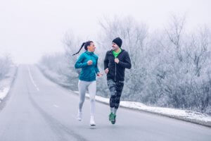 Couple running outside in winter.