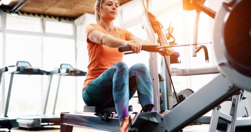 Woman using seated row machine at the gym
