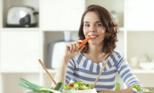 Woman eating carrot as antioxidant supplements