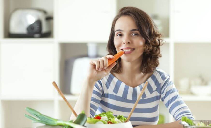 Woman eating carrot