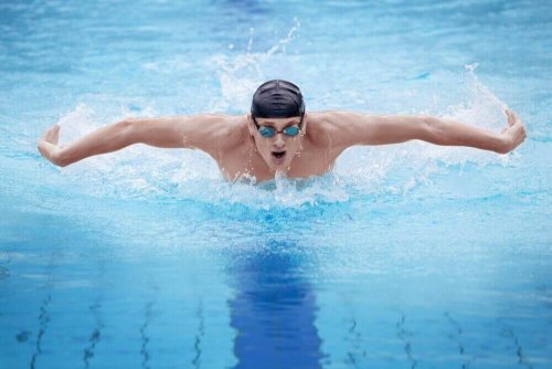 Man doing the butterfly stroke with swimming cap and goggles