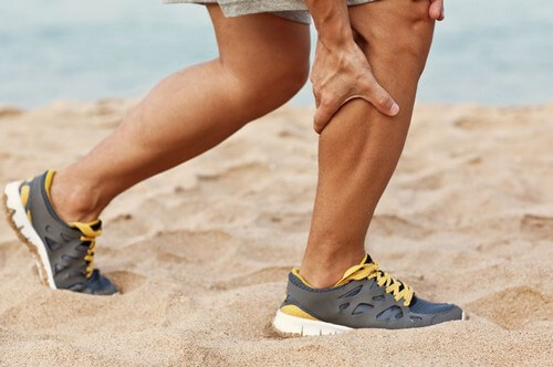 Man grabbing leg cramp