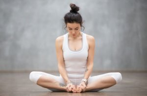 Woman sitting with her legs crossed doing hypopressive abdominal exercises