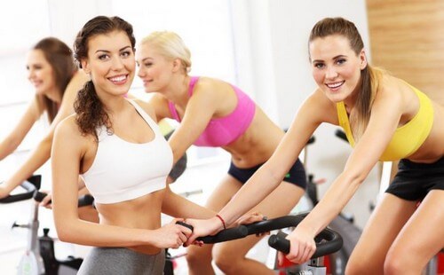Women at gym indoor cycling