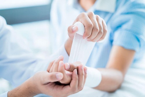 Person getting wrist wrapped in gauze