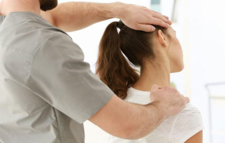 Physical therapist giving his patient a neck adjustment