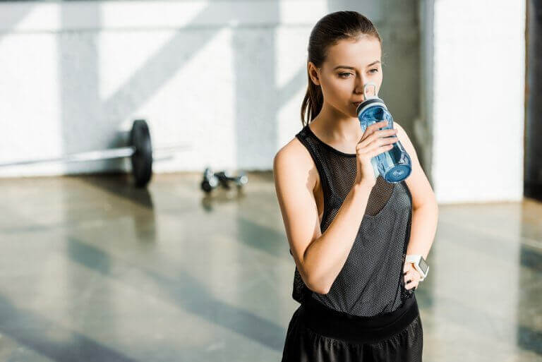 A woman drinking water to improve her physical performance