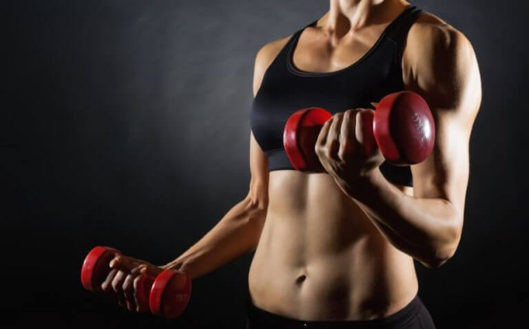 A woman lifting weights to burn fat and gain muscle at the same time