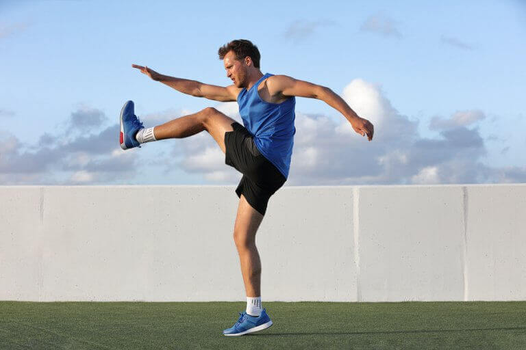 Man performing a knee raise to warm up before a training session