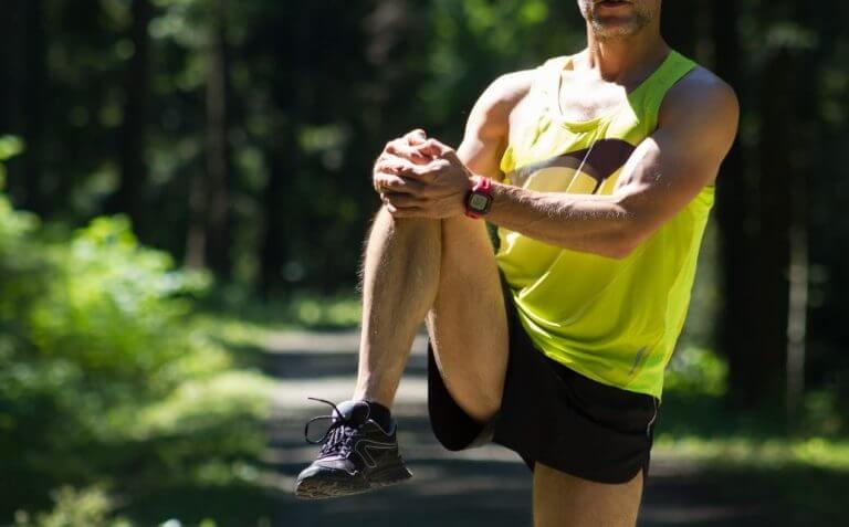 Man doing a knee raise to warm up his joints before running