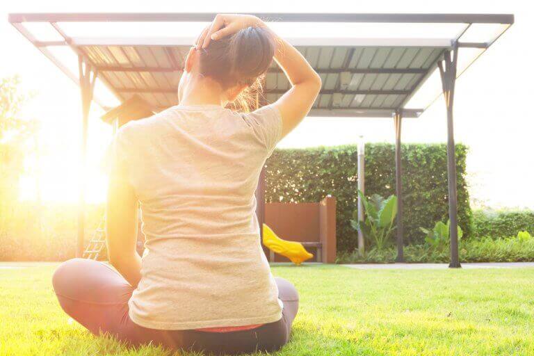 Woman performing different types of neck warm up exercises in her backyard