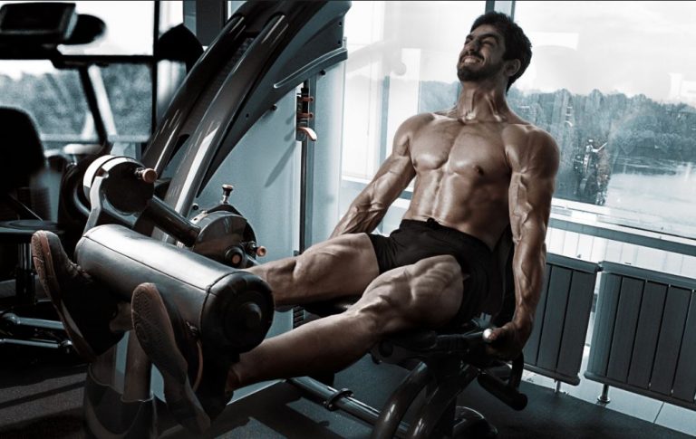 Man using a leg extension machine at the gym to strengthen his thighs
