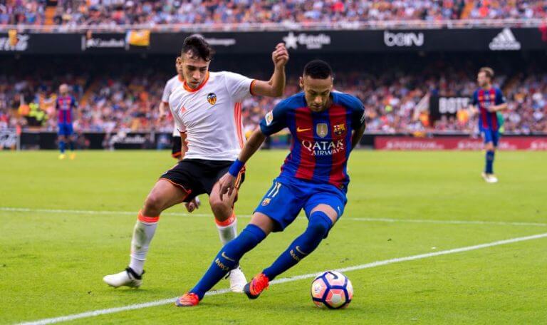 Two soccer players fighting over the ball