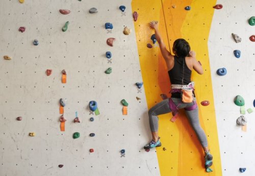 A woman climbing a rock climbing wall.