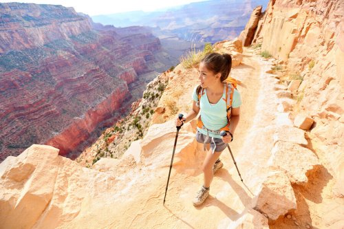 A woman hiking up a mountain in the day.