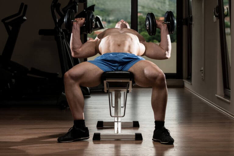 A man doing chest press exercises on an incline bench