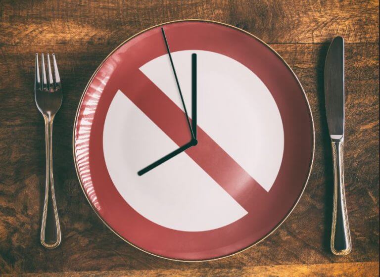 The illustration of a clock printed on a plate to simbolize intermittent fasting