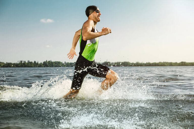 A man running near the shore of the ocean